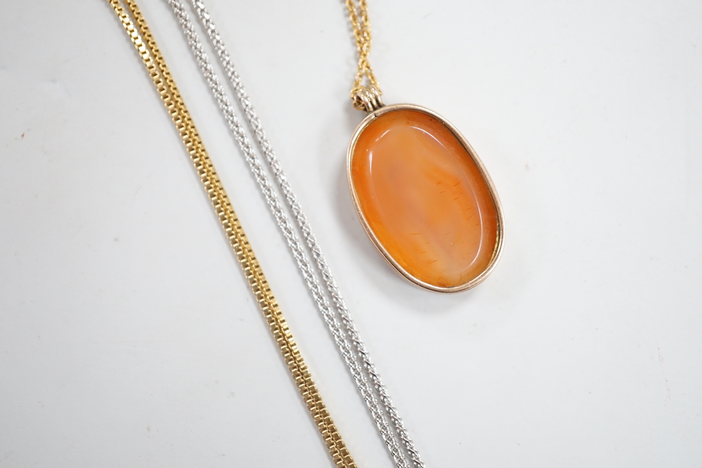 A yellow metal mounted oval intaglio carnelian stone, carved with the bust of gentleman to sinister, 23mm on a 9ct fine link, 37cm and two 9ct gold chains. including white gold, gross weight 8.7 grams.